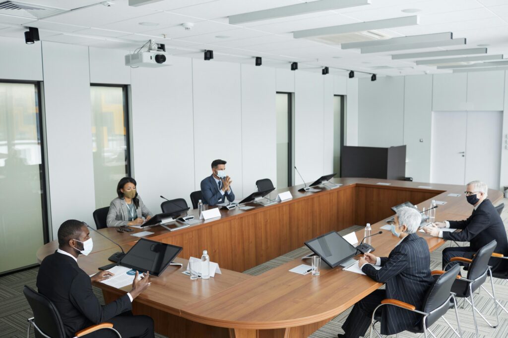 Senior business professionals in a formal boardroom meeting, representing high-level pharmaceutical or corporate strategy discussions