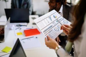 Pharma content professionals reviewing scientific data reports and analytics charts in a corporate office meeting